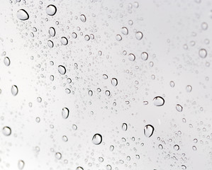 Drops of rain on the inclined window (glass).