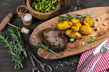 Beef steak with roasted potatoes in rustic kitchen