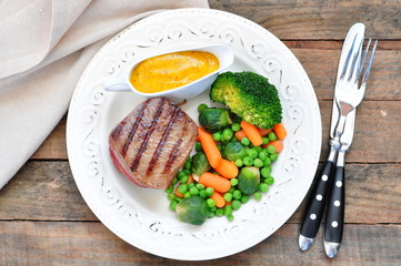 Juicy steak with a peas, broccoli and carrot