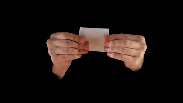 Magician shows trick with money on black background