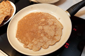 Pan with flaxseed meal pancake on a stove