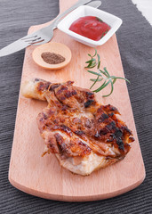 Juicy grilled fillet steak with tomatoes dip on an wooden board