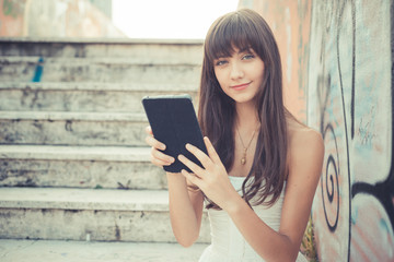 beautiful young woman with white dress using tablet