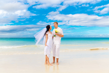 happy bride and groom having fun on a tropical beach
