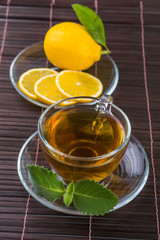 Glass cup of tea with mint and lemon