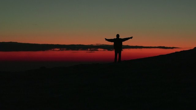 Man walking in the sunset at the mountains in winter