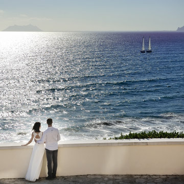 romantic couple looking at the sea in wedding day in Italy