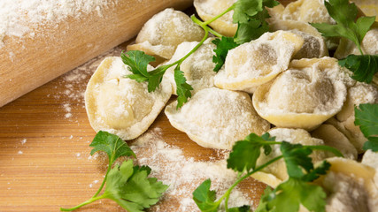 Homemade uncooked ravioli on wooden table