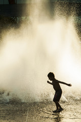 Fototapeta na wymiar Boy playing in front of a fountain