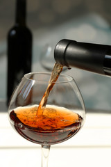 Red wine pouring into wine glass, close-up