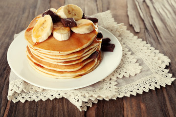 Stack of delicious pancakes with chocolate, honey and slices of
