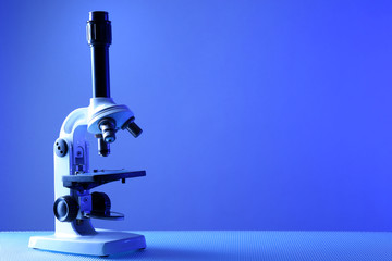Microscope on table, on color background