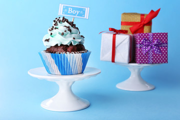 Delicious cupcake with inscription on blue background