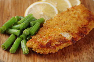 Breaded fried fillet and potatoes with asparagus and sliced