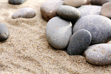 Fototapeta na wymiar Gray sea pebbles on sand background