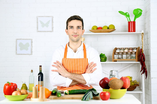 Man at table with different products and utensil in kitchen