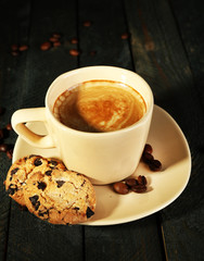 Cup of coffee and tasty cookies on wooden background