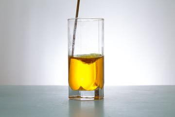 glass of yellow liquid and wand