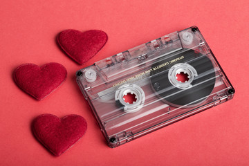 Audio cassette tape on red backgound with fabric heart