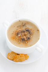 mushroom cream soup with croutons on white wooden table