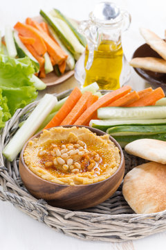 hummus with pita bread and fresh vegetables, vertical
