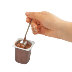 Spoon with chocolate pudding, coffee, baby food in hand on a whi