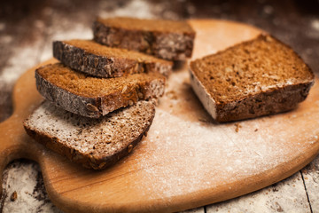 Sliced rye bread on cutting board closeup on table