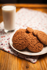 Oatmeal cookies and glass of milk on napkin on table