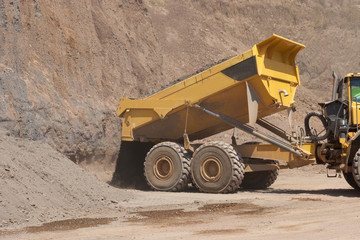 Truck and bulldozer work in the quarry