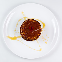 Pancakes with honey and cranberries on a plate.