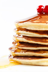 Pancakes with honey and cranberries on a plate.