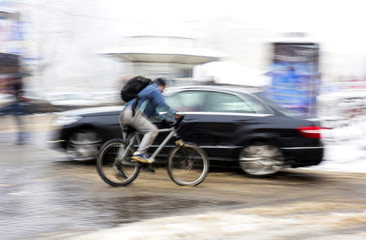 Fototapeta na wymiar Man on bicycle in the city in a snowy day.
