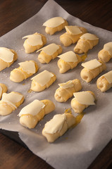 Mini croissants with cheese and sesame seeds ready for baking