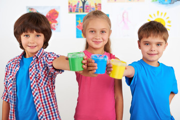 Children holding colorful cans with paint