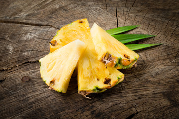 Pineapple. Slices isolated on wooden background.
