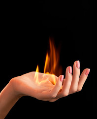 Female hand with pink nail design and fire on black background