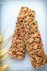 Muesli bars, cereal bars on the wooden background.