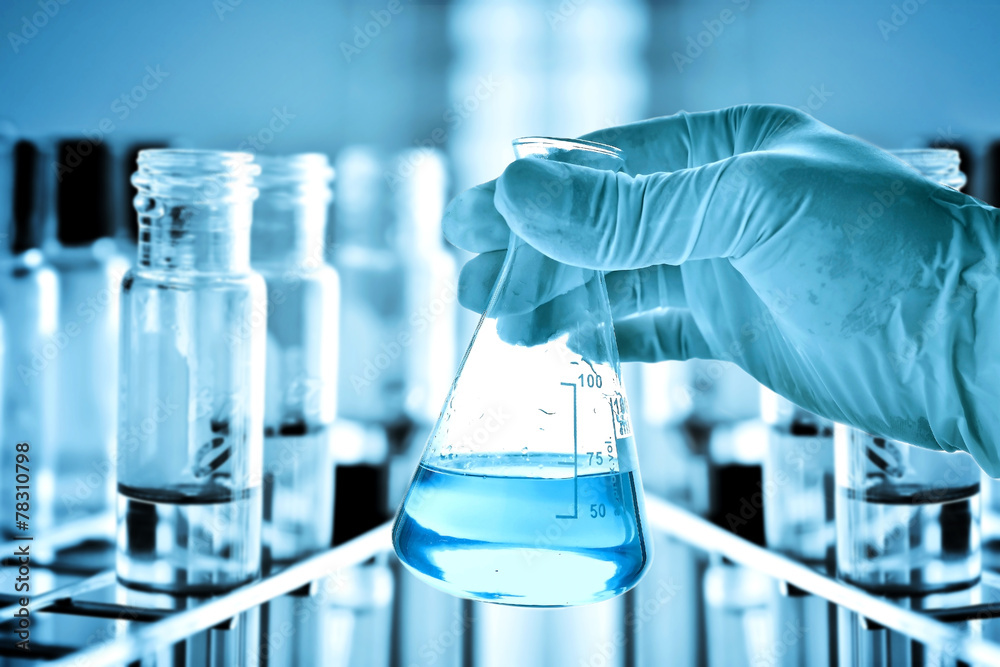 Wall mural flask in scientist hand with laboratory background