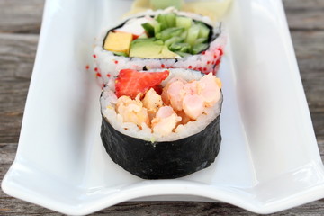 Sushi rolls entry on old wooden board