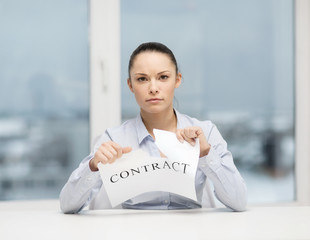 serious businesswoman tearing contract