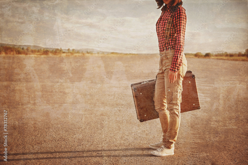 Wall mural Woman with suitcase on road, vintage image