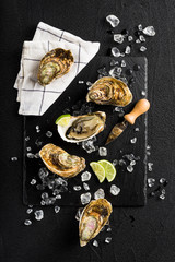 Fresh oysters on a black stone plate top view - 78314700