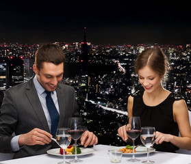 smiling couple eating main course at restaurant