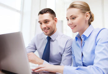 smiling businesspeople with tablet pc in office