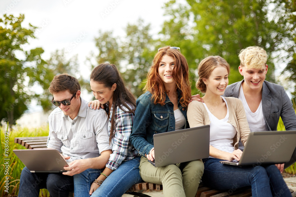 Poster students or teenagers with laptop computers