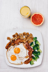 Fried eggs and bacon with broccoli and croûtons