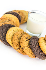 variety of cookies around a glass of milk