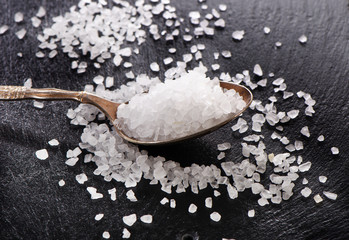 salt in a spoon on  black background