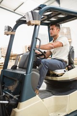 Driver operating forklift machine in warehouse