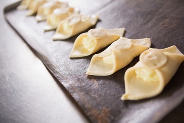 Close up of baker holding tray of raw dough